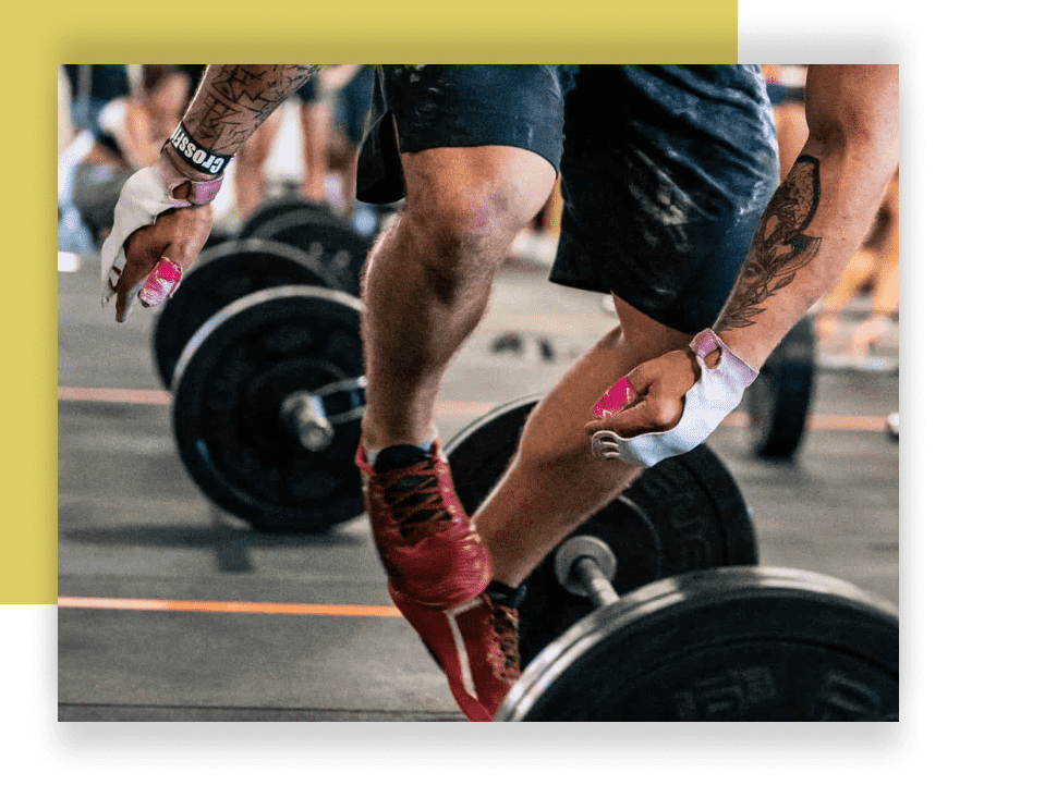 Athlete jumping over a barbell while wearing thumb tape on his fingers